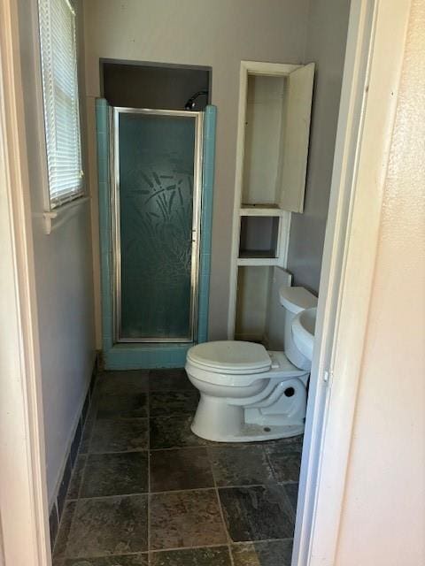 bathroom with a shower with shower door and toilet