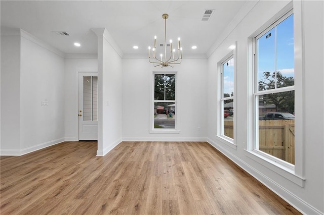 unfurnished dining area with an inviting chandelier, light hardwood / wood-style flooring, and ornamental molding