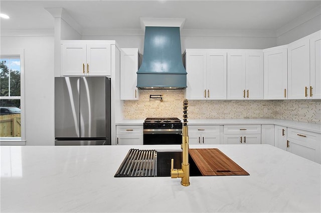 kitchen featuring stainless steel appliances, white cabinetry, tasteful backsplash, and custom exhaust hood