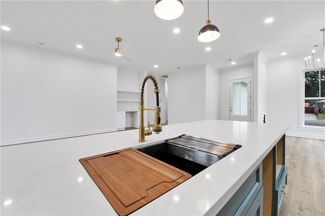 kitchen with crown molding, ceiling fan, light hardwood / wood-style flooring, and hanging light fixtures