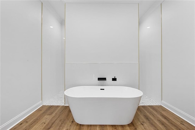 bathroom with wood-type flooring and a bathtub