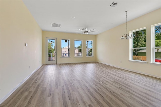 interior space featuring ceiling fan with notable chandelier and light hardwood / wood-style floors