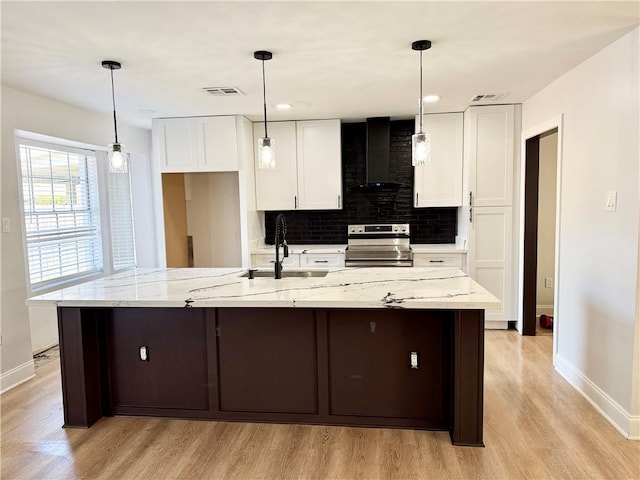 kitchen with a large island, white cabinetry, wall chimney exhaust hood, and stainless steel electric range oven