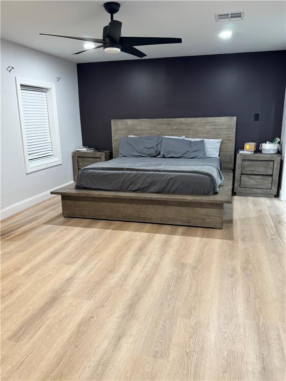 bedroom with light hardwood / wood-style flooring and ceiling fan