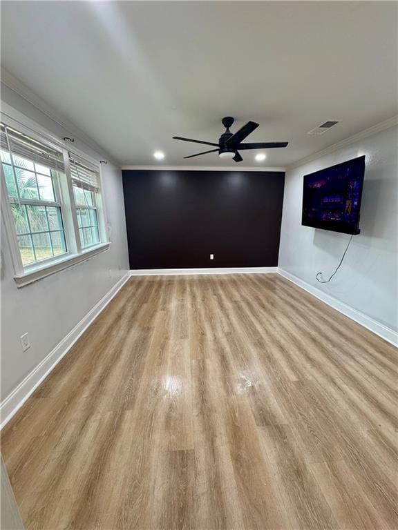 empty room featuring ornamental molding, light hardwood / wood-style floors, and ceiling fan