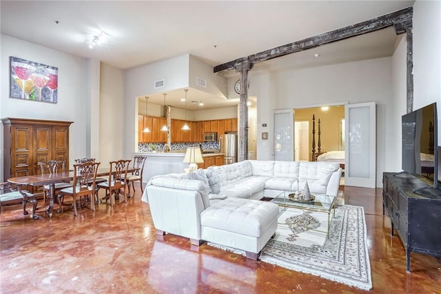 living room featuring concrete flooring and a high ceiling