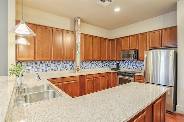 kitchen with kitchen peninsula, tasteful backsplash, stainless steel appliances, sink, and pendant lighting