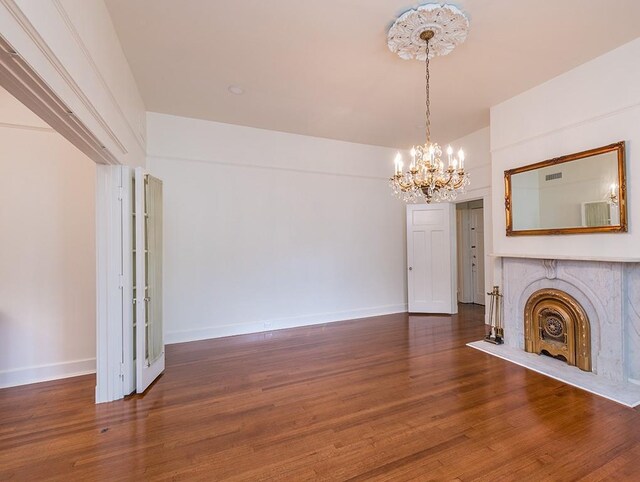 unfurnished living room featuring a chandelier and dark hardwood / wood-style floors