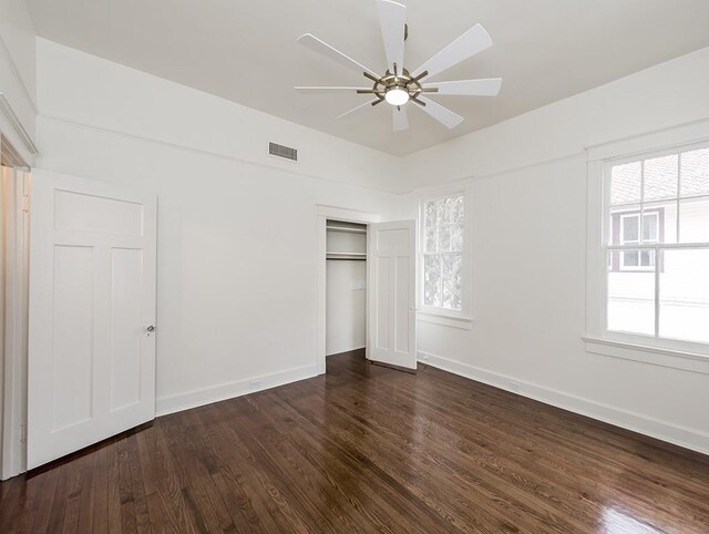 unfurnished bedroom featuring dark wood-type flooring, ceiling fan, and a closet