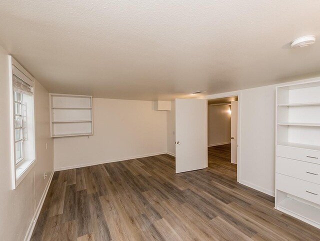 interior space featuring a textured ceiling and dark hardwood / wood-style floors