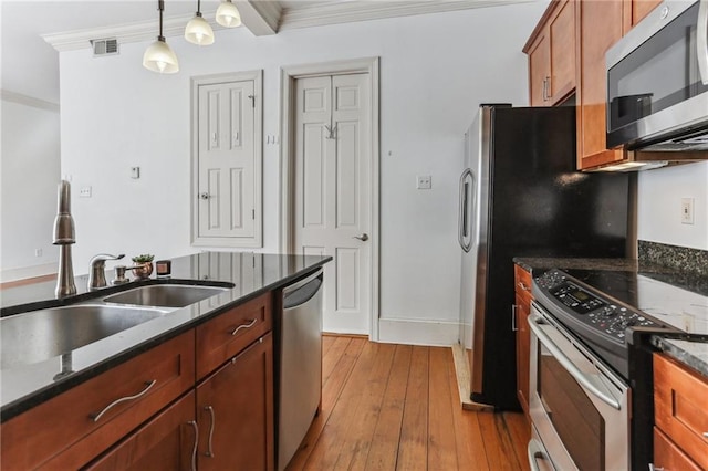 kitchen featuring light hardwood / wood-style floors, crown molding, hanging light fixtures, and appliances with stainless steel finishes