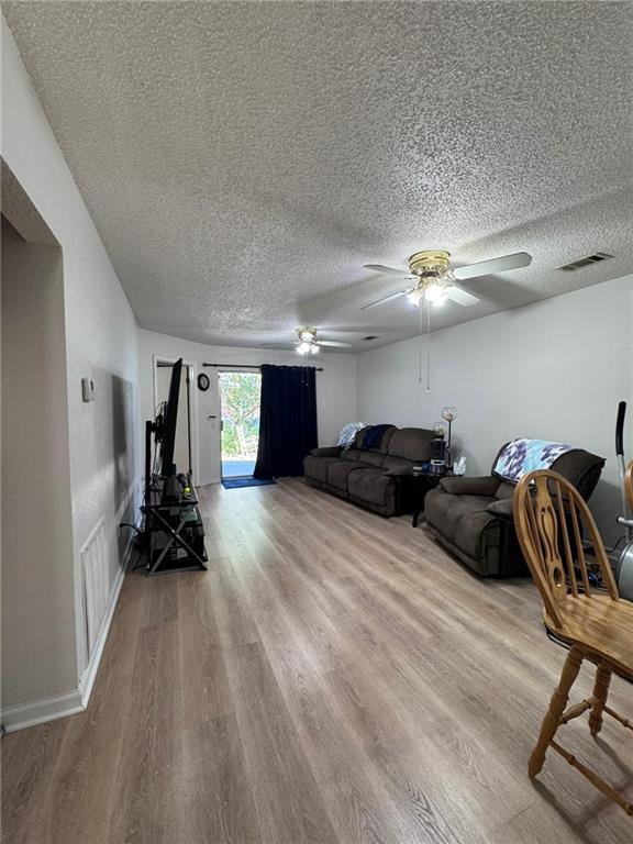 living room featuring a textured ceiling and light hardwood / wood-style flooring