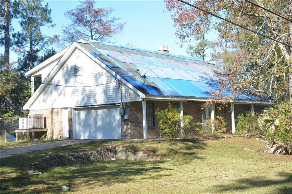 3303 Bonfouca Dr, Slidell, LA 70458 - view of front of property featuring solar panels, a garage, and a front yard