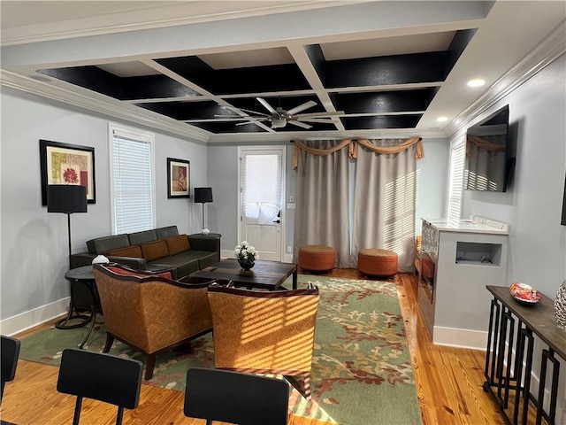 living room featuring coffered ceiling, ceiling fan, light wood-type flooring, ornamental molding, and beamed ceiling