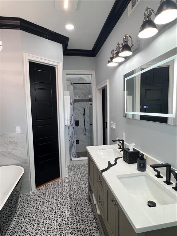 bathroom featuring vanity, crown molding, plus walk in shower, and tile walls