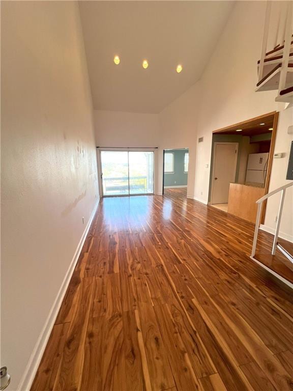 unfurnished living room featuring dark hardwood / wood-style floors and high vaulted ceiling