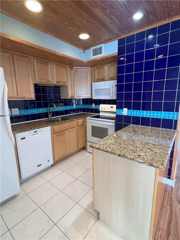 kitchen featuring sink, backsplash, dark stone counters, white appliances, and wood ceiling