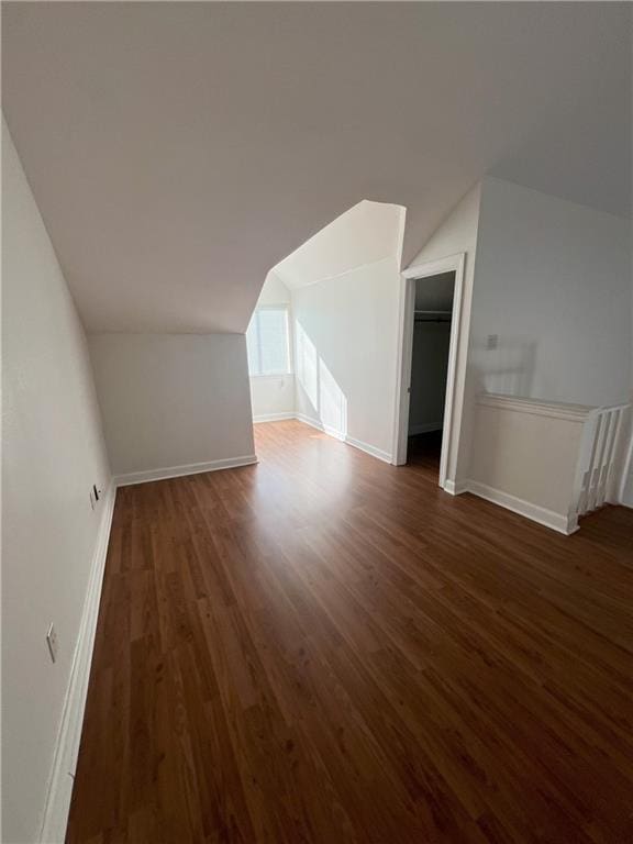 bonus room with dark hardwood / wood-style floors and lofted ceiling