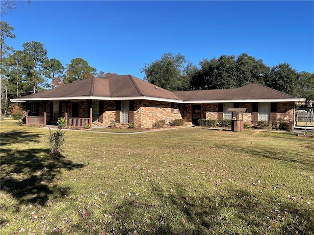 view of front of property with covered porch, a front lawn, and brick siding