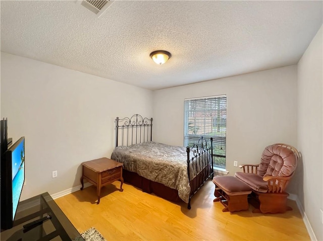 bedroom featuring wood-type flooring and a textured ceiling