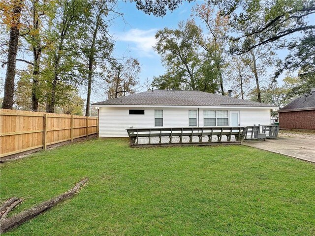 rear view of property with a lawn and a deck