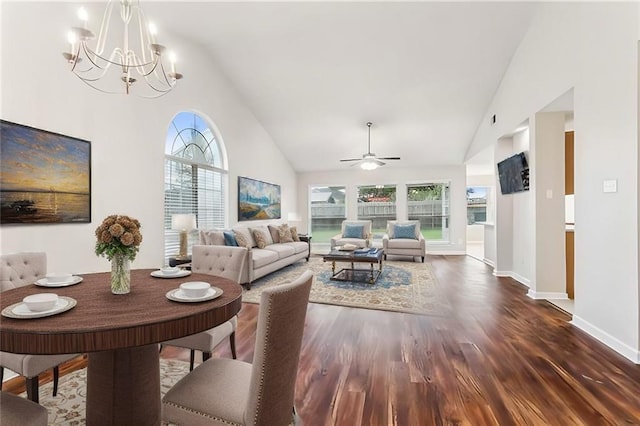 living room featuring ceiling fan with notable chandelier, dark hardwood / wood-style flooring, and high vaulted ceiling