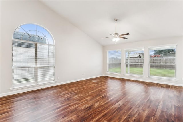 spare room featuring a wealth of natural light, ceiling fan, dark wood-type flooring, and high vaulted ceiling