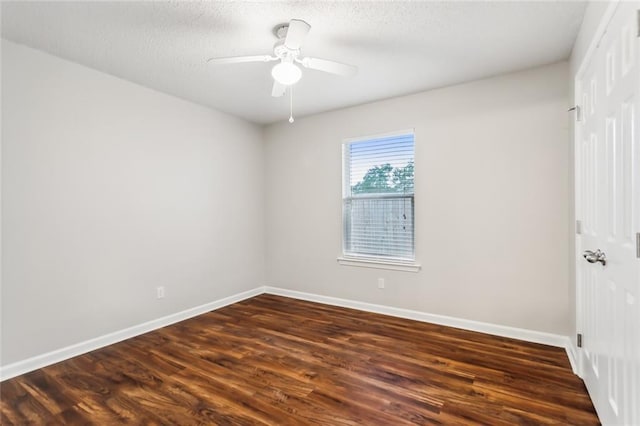 spare room featuring a textured ceiling, ceiling fan, and dark wood-type flooring