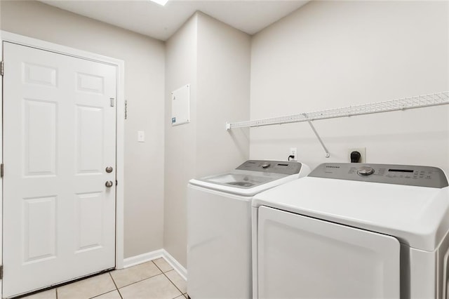 laundry area featuring light tile patterned floors and washer and dryer