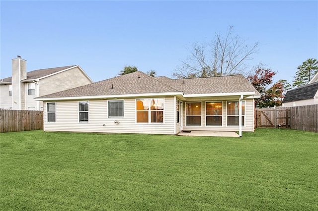 rear view of property featuring a yard and a patio