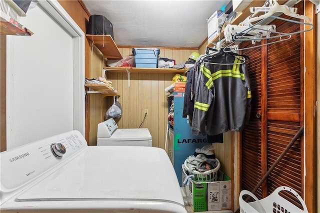 washroom with wood walls and washer and clothes dryer