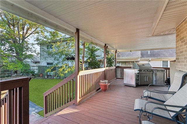 wooden deck with grilling area and a lawn