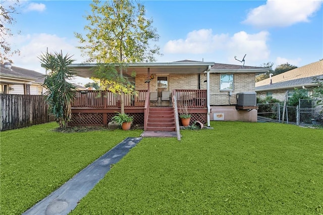 rear view of property featuring a lawn, cooling unit, and a wooden deck