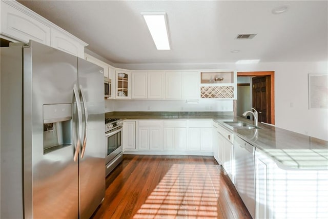 kitchen with dark hardwood / wood-style flooring, white cabinetry, sink, and appliances with stainless steel finishes