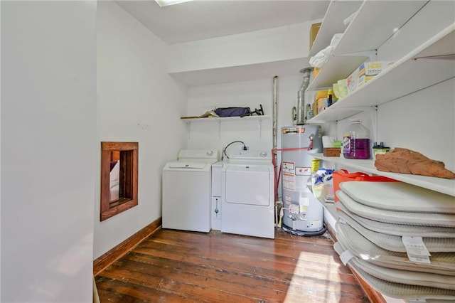 laundry area with water heater, washing machine and clothes dryer, and dark hardwood / wood-style flooring