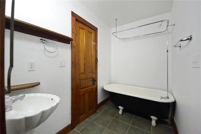 bathroom featuring tile patterned floors, sink, and a bath