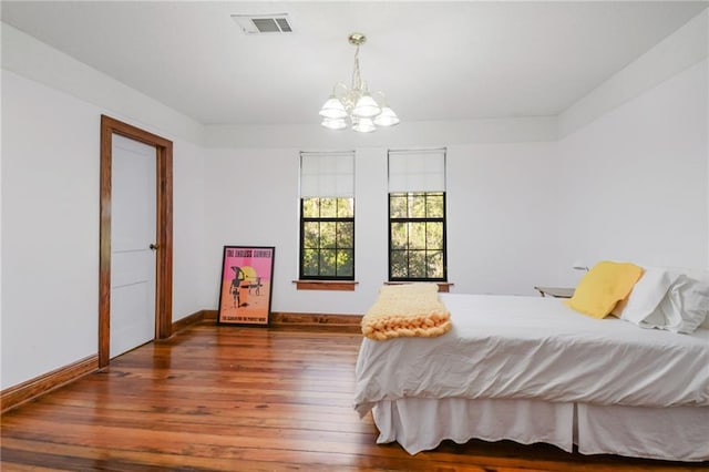 bedroom with a notable chandelier and dark hardwood / wood-style floors