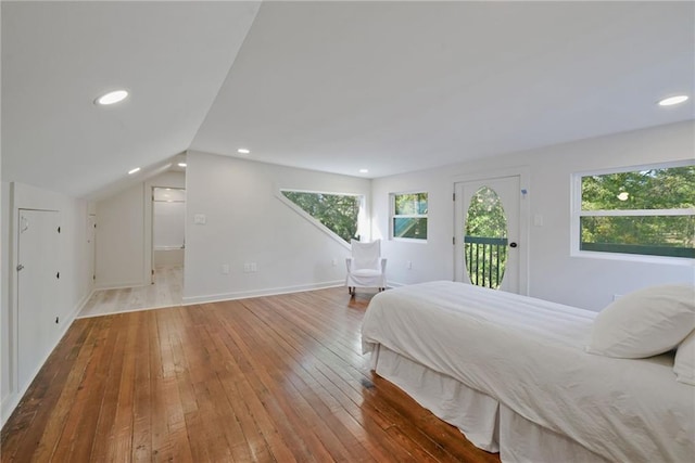 bedroom featuring lofted ceiling, wood-type flooring, and access to exterior