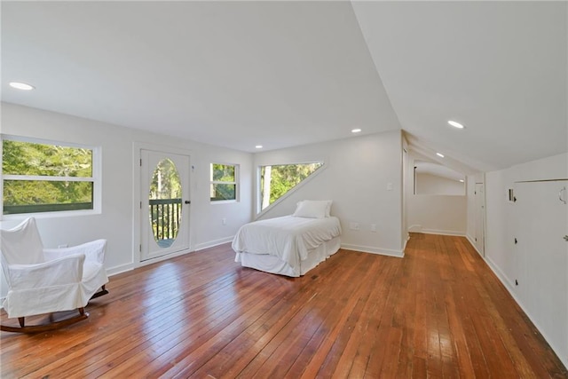 unfurnished bedroom featuring access to exterior, wood-type flooring, and vaulted ceiling