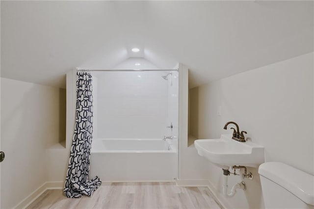 bathroom with shower / tub combo with curtain, hardwood / wood-style floors, vaulted ceiling, and toilet