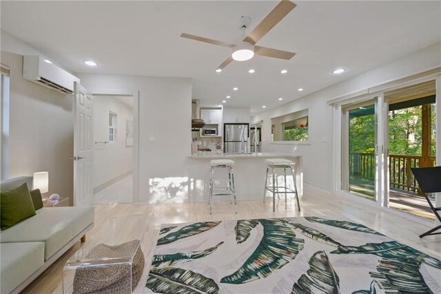 living room with ceiling fan and a wall mounted AC