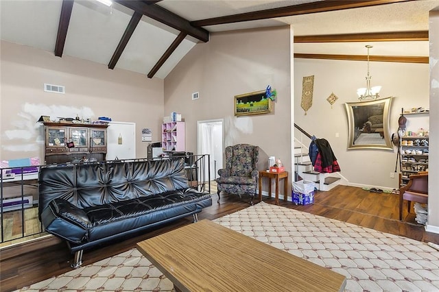 living room featuring beamed ceiling, hardwood / wood-style flooring, high vaulted ceiling, and a chandelier