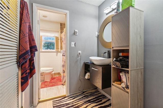 bathroom featuring hardwood / wood-style floors, toilet, and sink