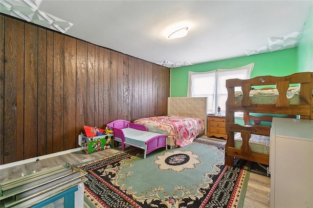 bedroom featuring wood walls and light hardwood / wood-style flooring