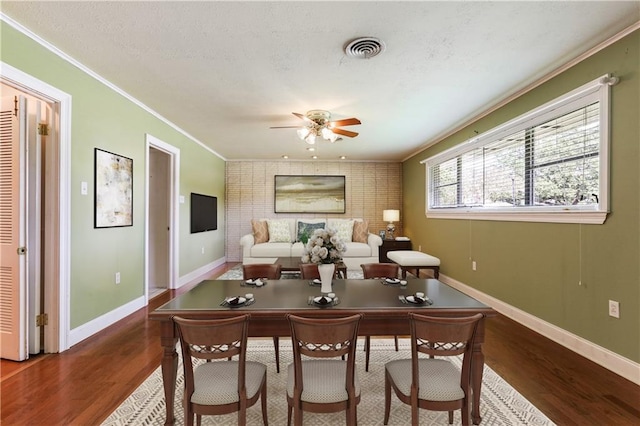 interior space featuring ceiling fan, dark wood-type flooring, and ornamental molding