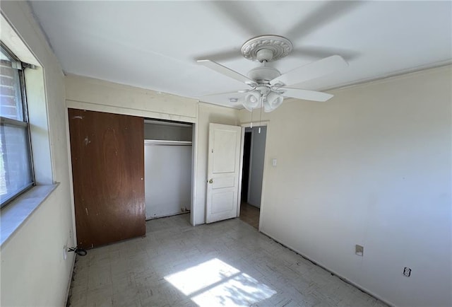 unfurnished bedroom with ceiling fan, a closet, and multiple windows