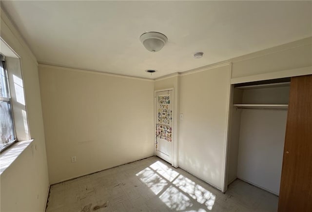 unfurnished bedroom featuring crown molding and a closet