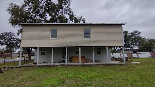 rear view of house with a lawn and a patio