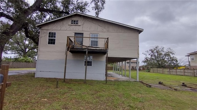 rear view of house featuring a balcony and a lawn