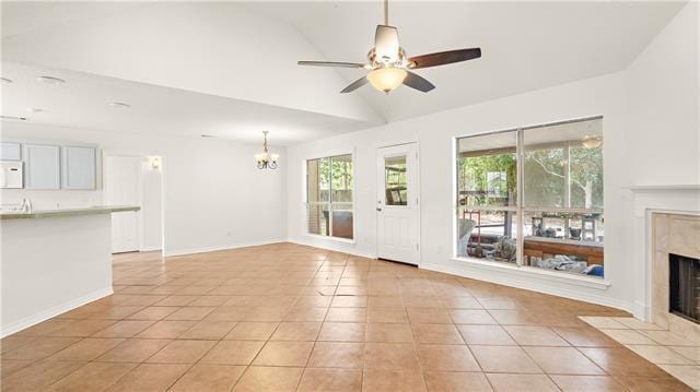 70081 9th St, Covington, LA 70433 - unfurnished living room featuring a premium fireplace, a chandelier, lofted ceiling, light tile patterned flooring, and ceiling fan